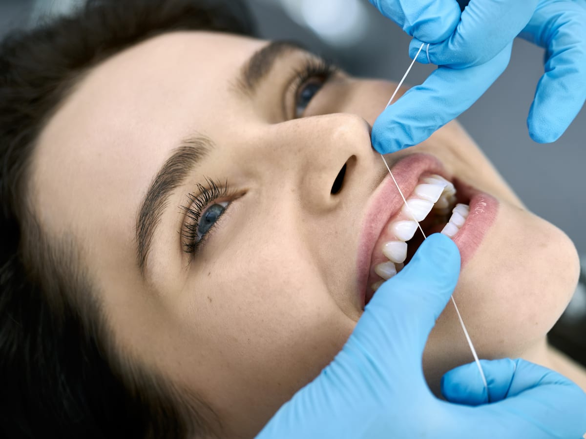 Woman getting her teeth flossed